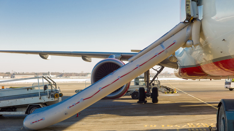 A plane's emergency slide deployed on a runway.