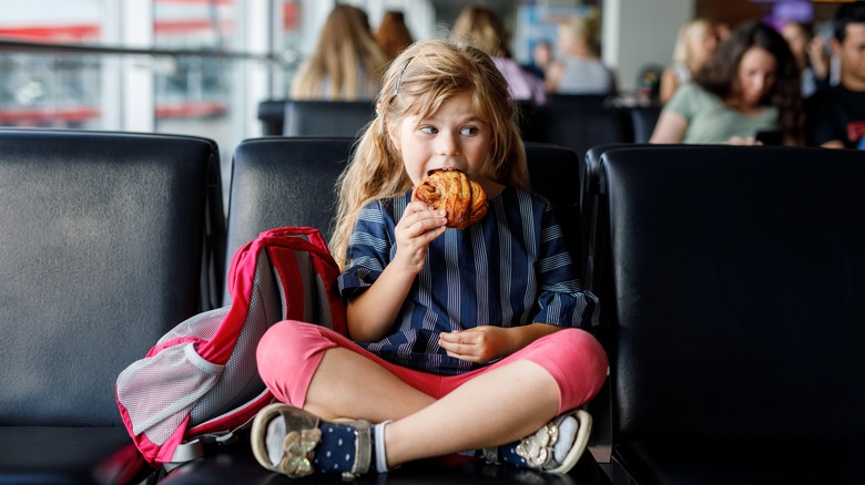 Child eating a pastry at the airport