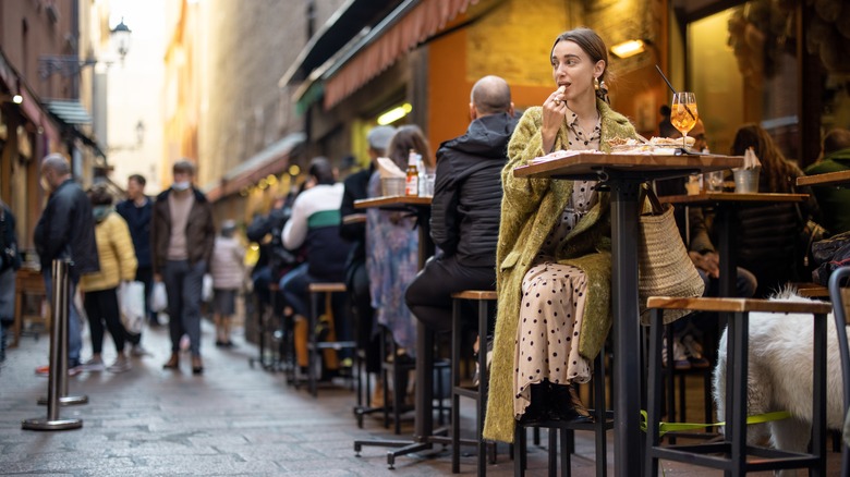 Italians sitting on stools eating