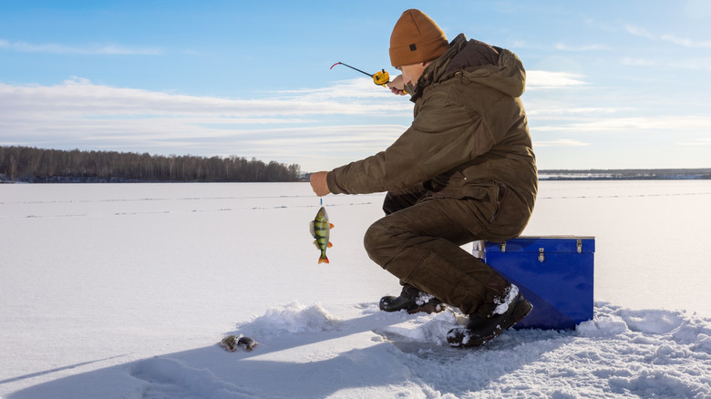 Fisherman ice fishing on a lake in winter