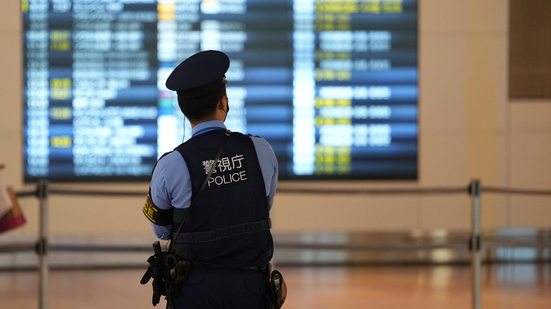 Japanese policeman airport flight board