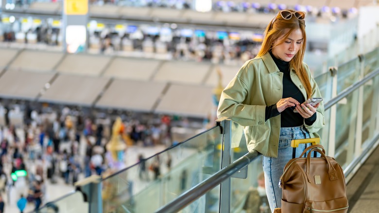 Woman consulting phone at airport 