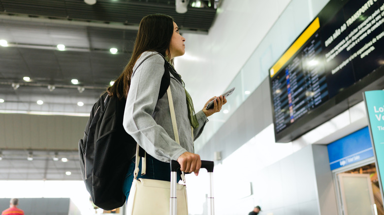 Woman checking board at airport