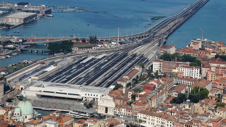 Aerial view of trains, ocean, and city