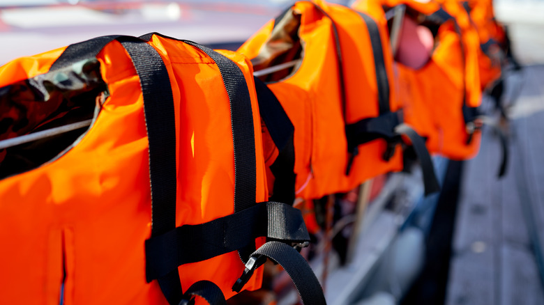 Bright orange life jackets hanging in a row