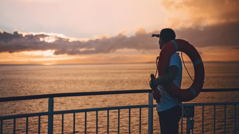 Man holding lifebuoy on ship