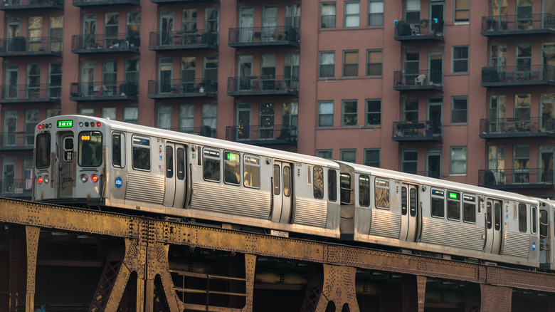 elevated train traveling by buildings