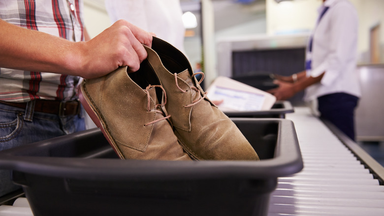 Putting shoes in security tray