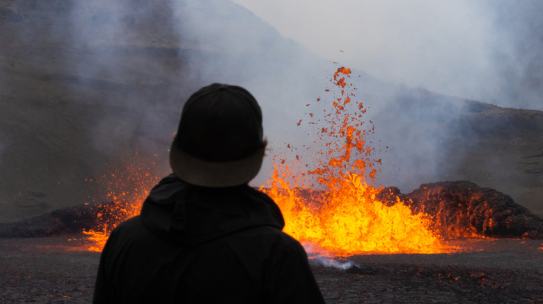 A travelers watches a volcano erupt in Iceland