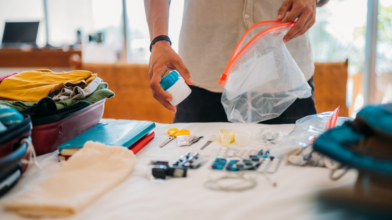 Traveler packing toiletries in bag