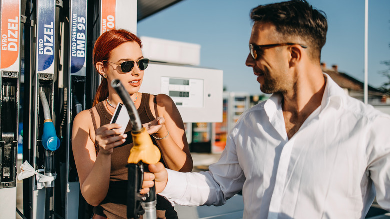 Couple refueling their vehicle