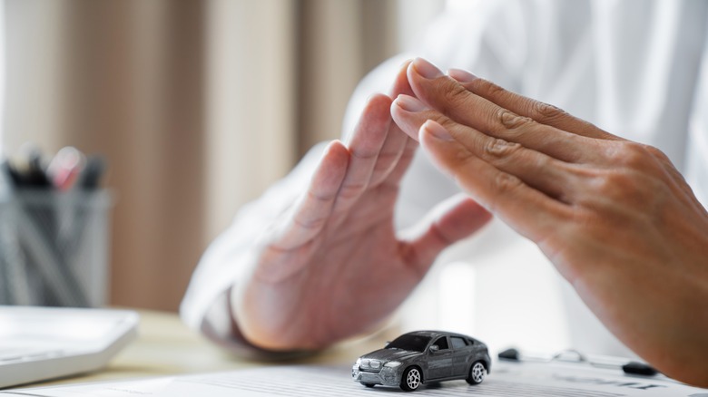 hands covering miniature rental car
