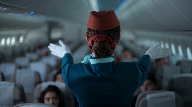 Flight attendant doing safety demonstration