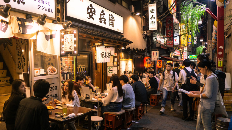 People sitting at outdoor bars on Japanese street