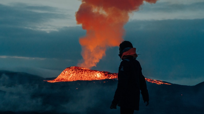 Hiker overlooking volcanic eruption