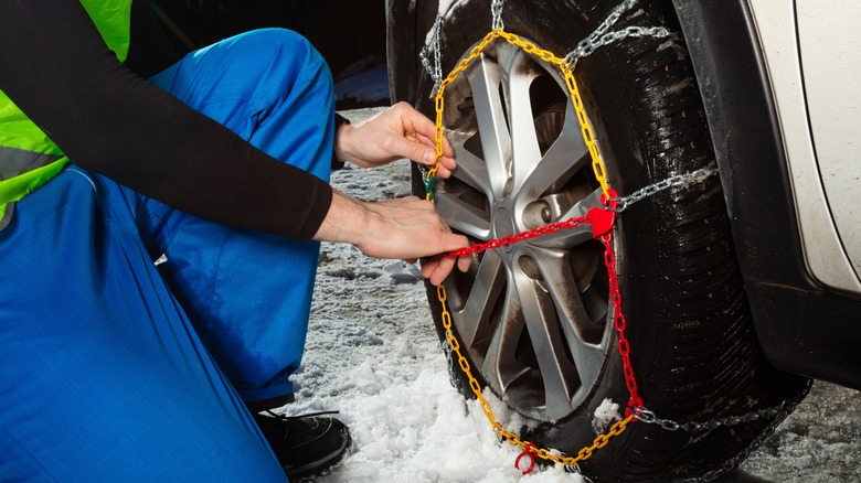 person installing tire chains