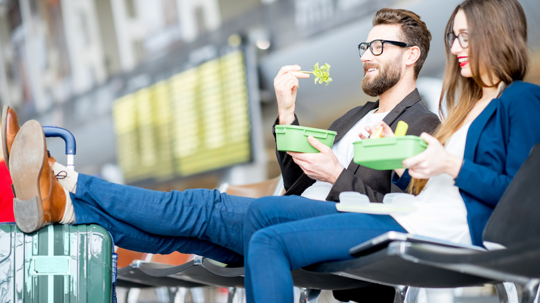 Couple eating salad at airport