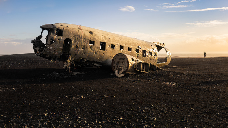 Crashed airplane in black sand.