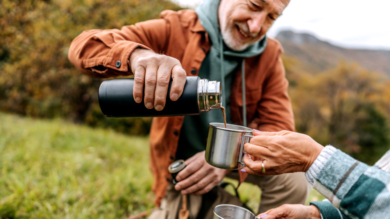 man pouring coffee from thermos