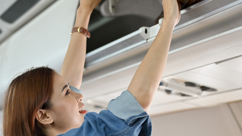 Putting luggage in overhead bin