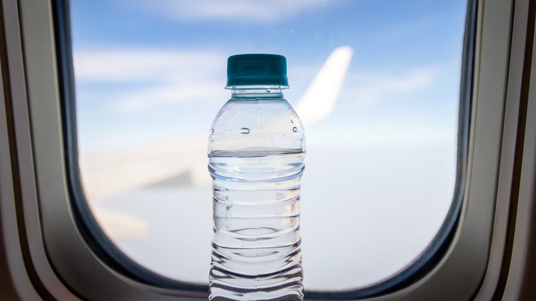 Bottled water by airplane window
