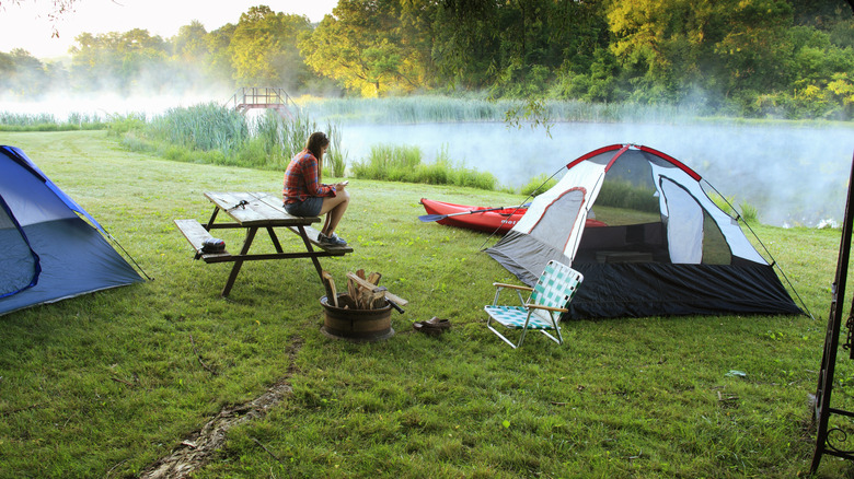 woman sitting on picnic table at campsite