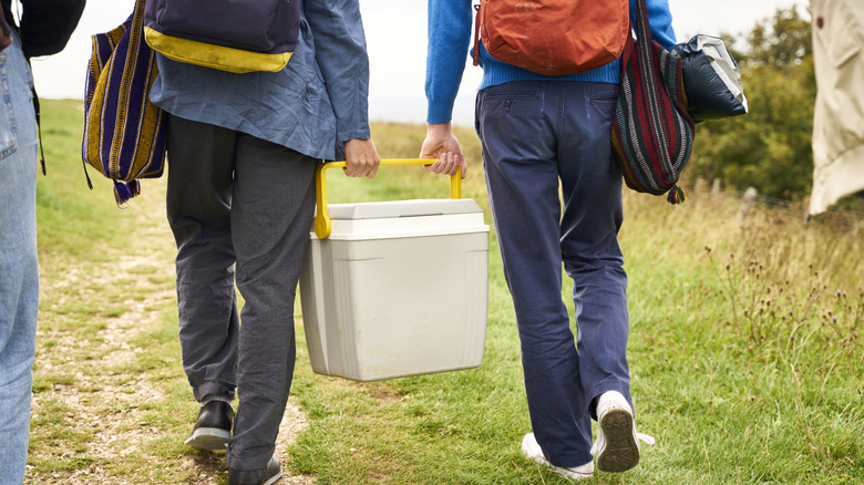 campers carrying a cooler