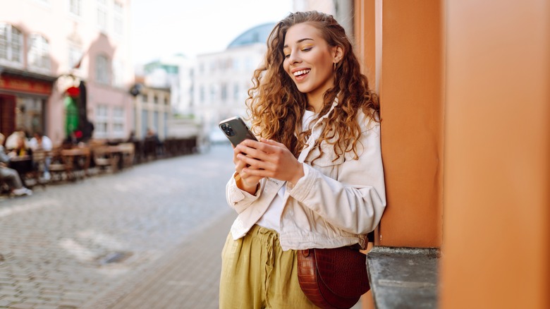 Smiling traveler using smartphone