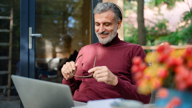 Older man using laptop outside