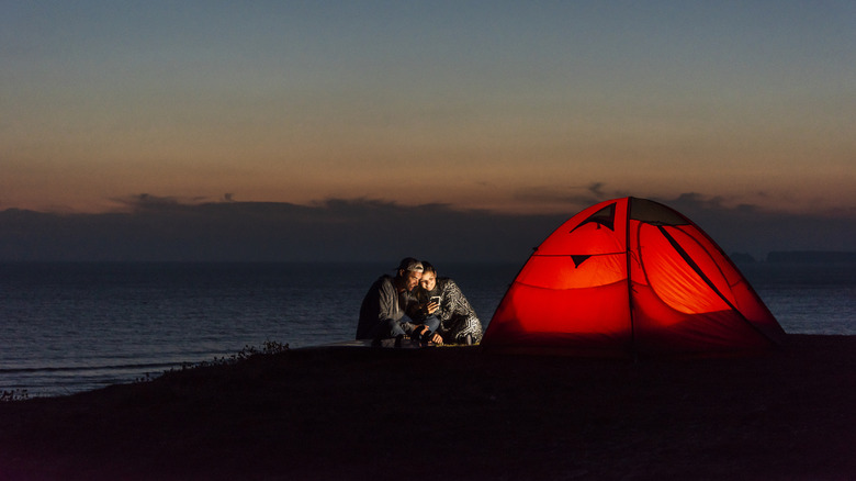 Couple beach camping at night