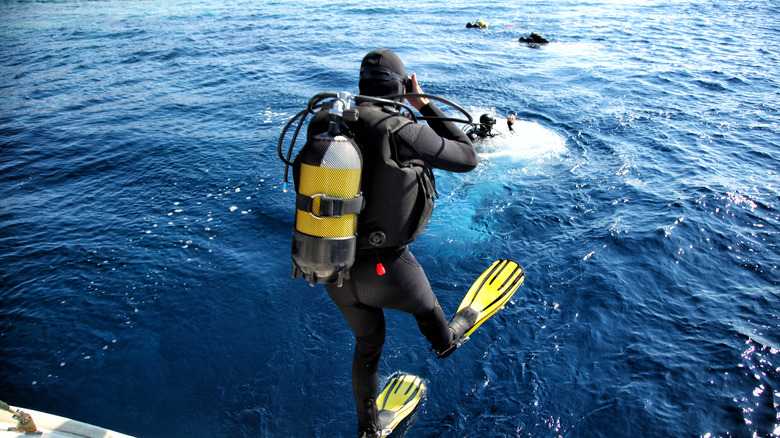 Scuba diver jumping into water