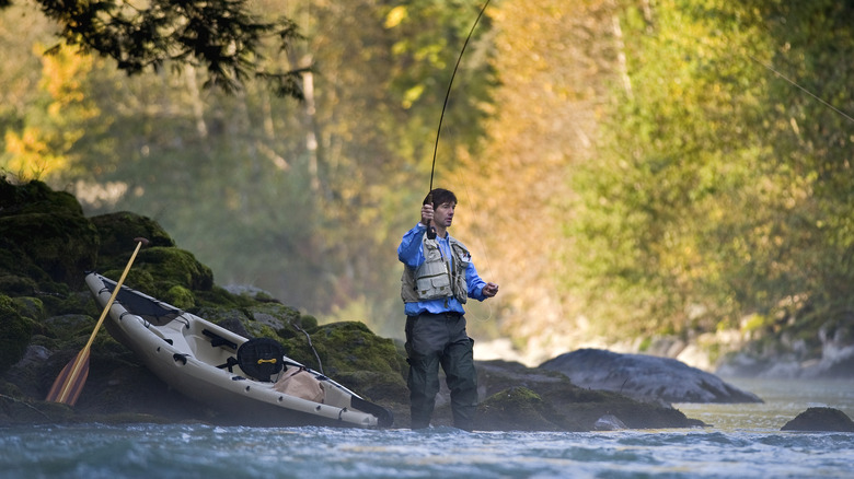 Fisherman casting line in creek