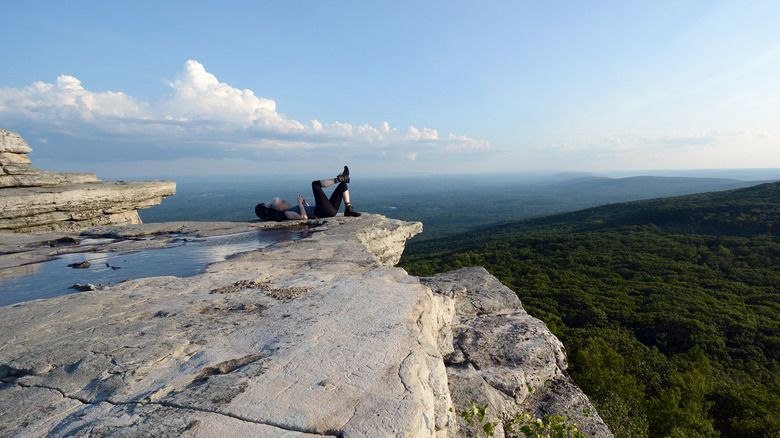 Person relaxing atop rocky viewpoint