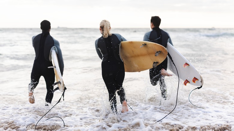 Group of surfers walking into water