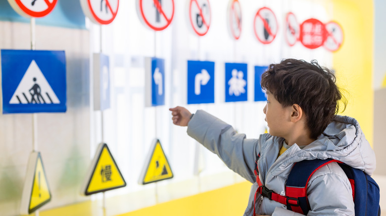 Child looking at Chinese road signs