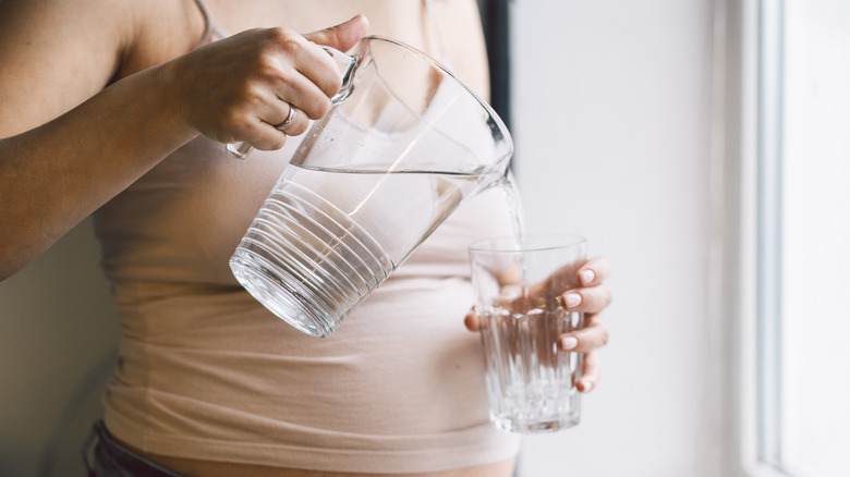 pregnant woman pouring water