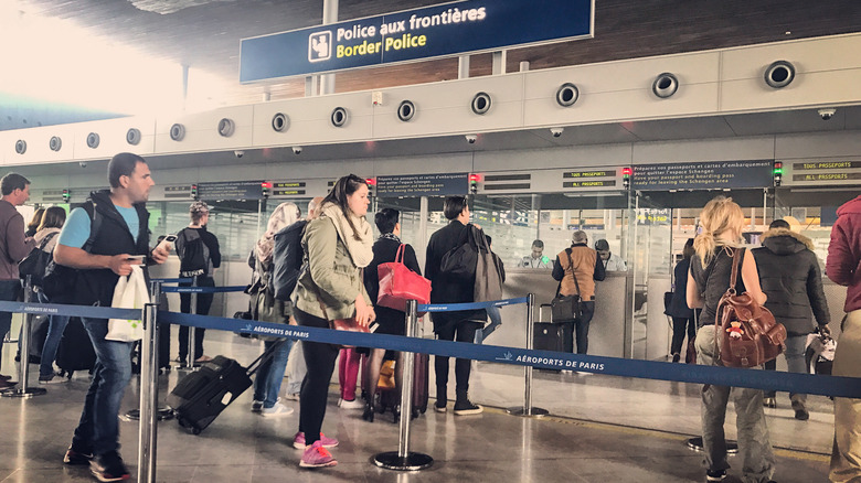 Travelers waiting at passport control at an airport in Paris