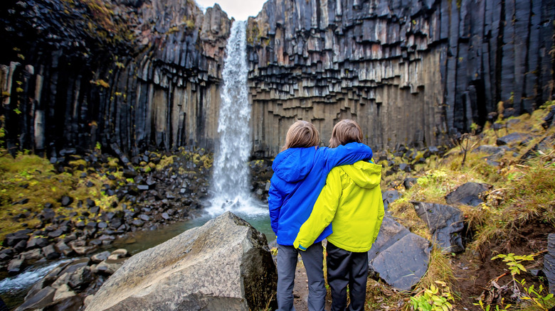 Kids embracing at Icelandic waterfall