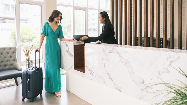 A woman checking into a hotel. 