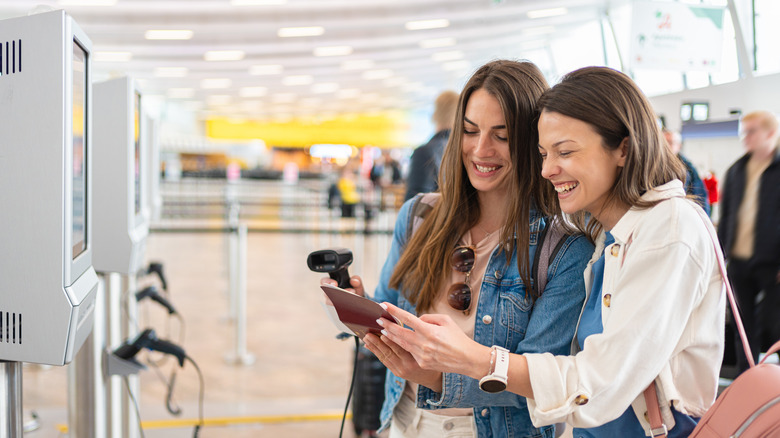 Two women checking in at airport