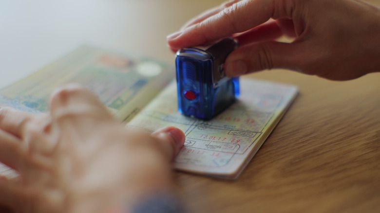 Hands holding stamped passport