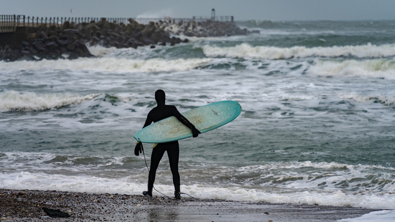 A Nordic surfer standing on the shore at Klitmoller in Denmark