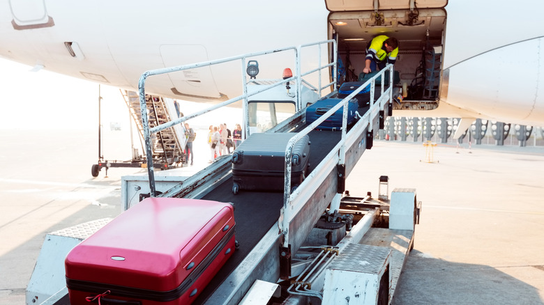 suitcases going up conveyor belt into plane