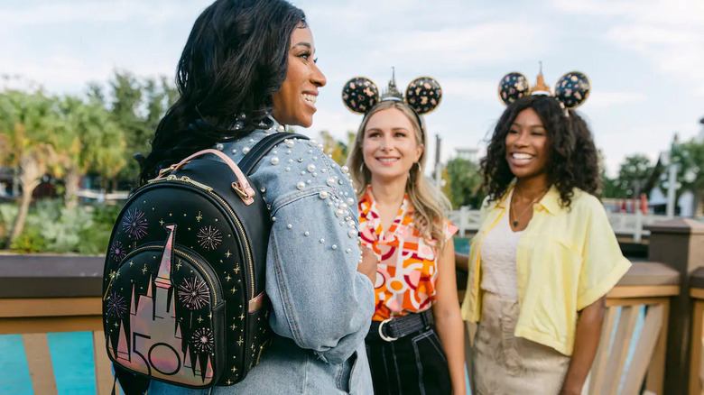 woman modeling Loungefly mini backpack with Cinderella Castle on it