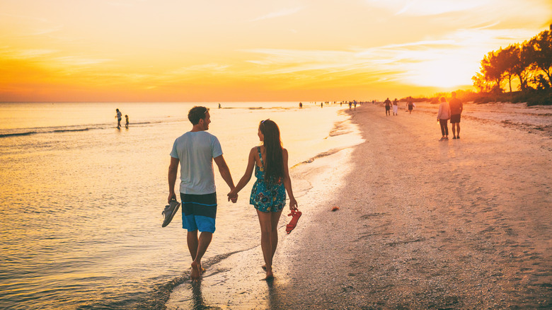 Couple walking Sanibel Island beach, Florida