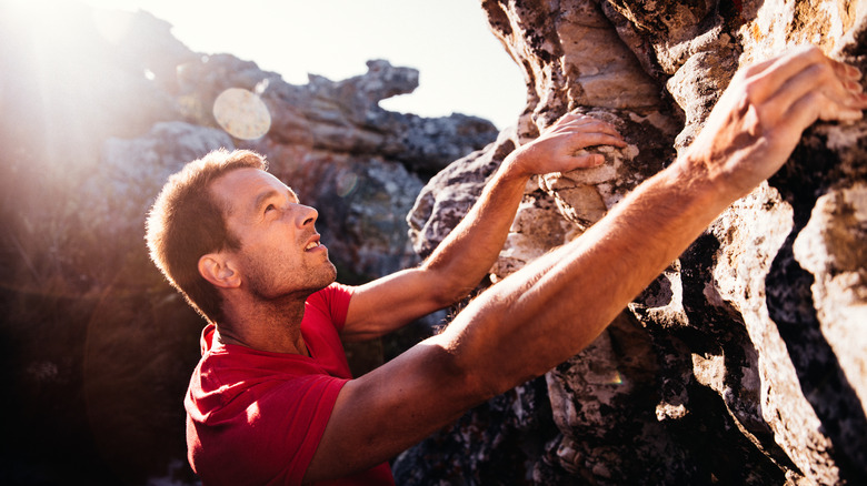 Man free climbing a boulder