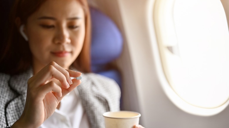 Woman with pill on plane