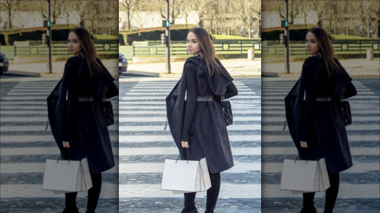 Woman walking along French streets in a black coat and stylish bag