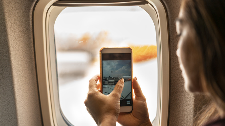 Woman takes photo inside airplane