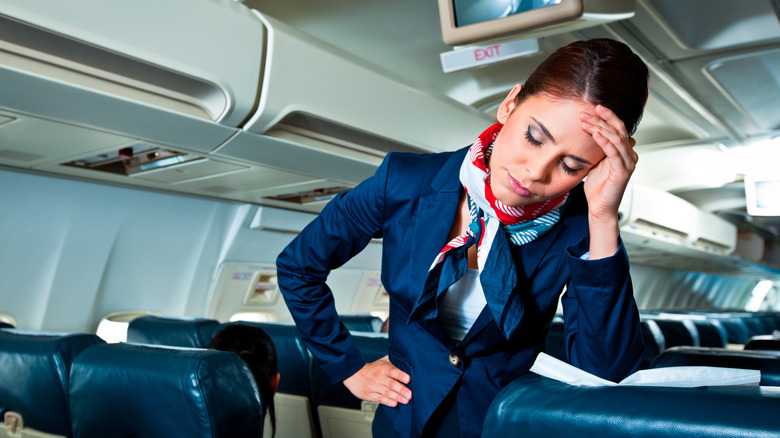 tired flight attendant with a headache